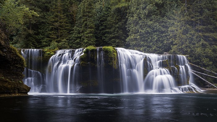 Wide waterfall cascading over mossy rocks in a forest