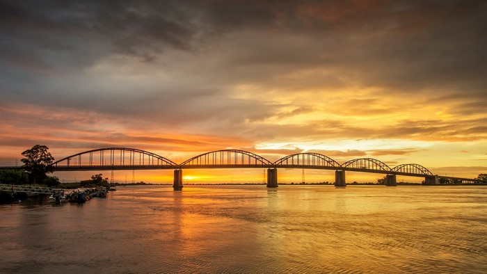 Bridge over river at sunset with clouds