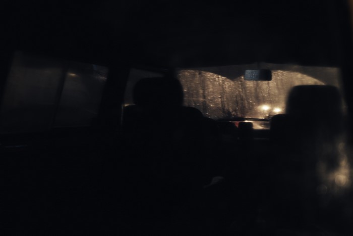 Car interior at night with rain on the windshield