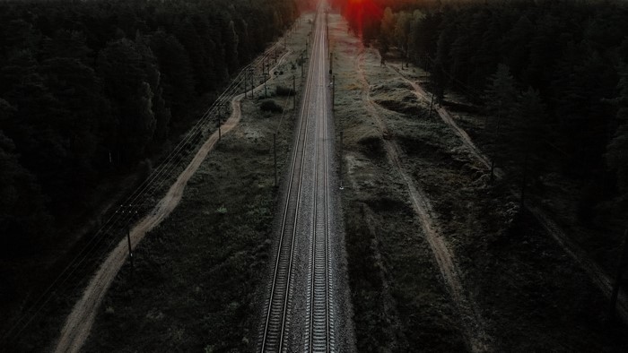 4K dark railway through trees