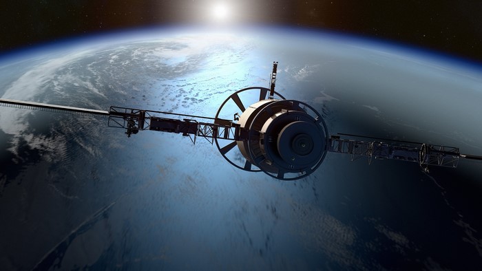 Satellite orbiting Earth with sun in background
