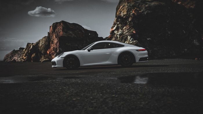 White Porsche 992 parked on a dark beach