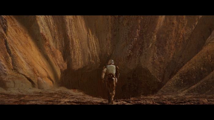 The Mandalorian walking in a canyon