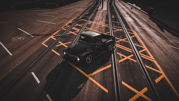 Black Ford F100 pickup truck on tram tracks