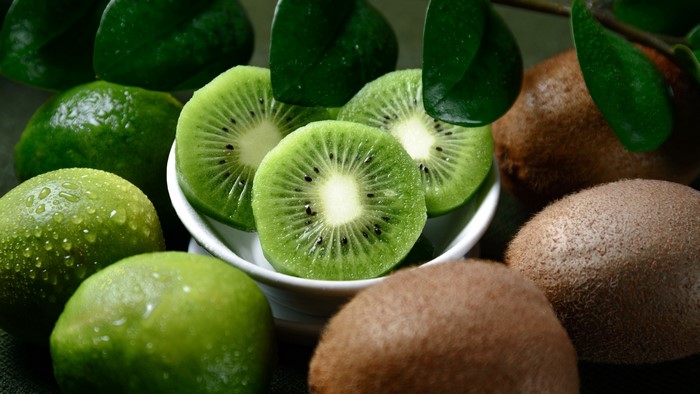 Kiwi slices and limes with leaves