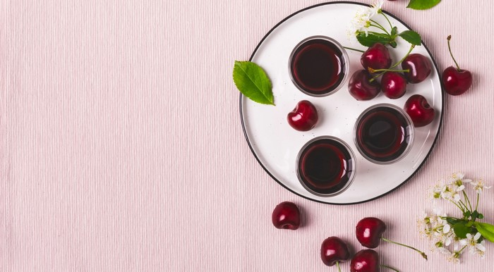 Cherries and cherry juice in glasses on a plate