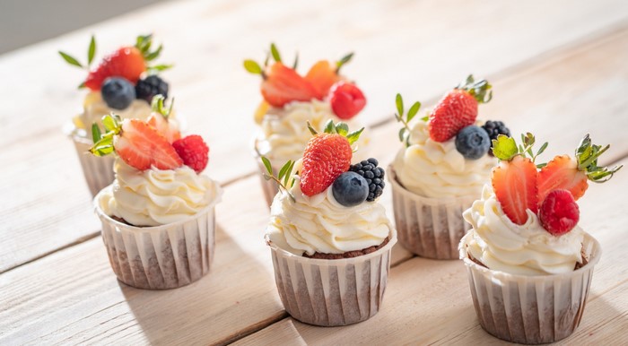 Cupcakes with fresh berries and cream frosting