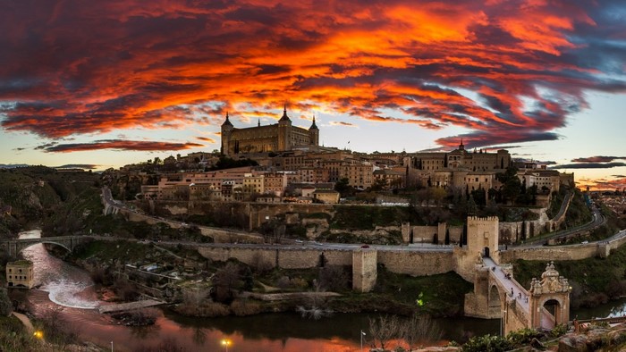 Toledo, Spain at sunset with dramatic clouds over the city and river