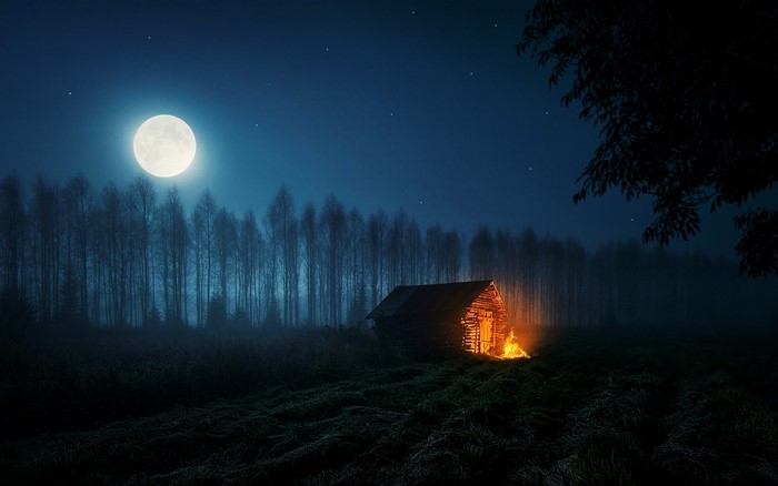 Cabin with fire under the moon and stars