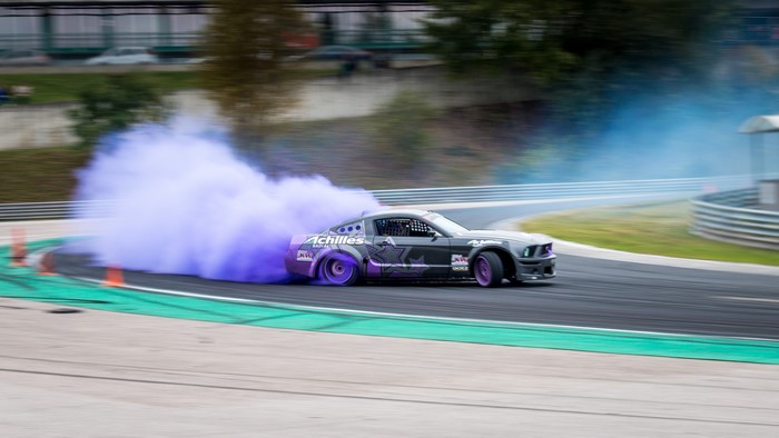 Ford Mustang Drifting with Purple Smoke on Racetrack