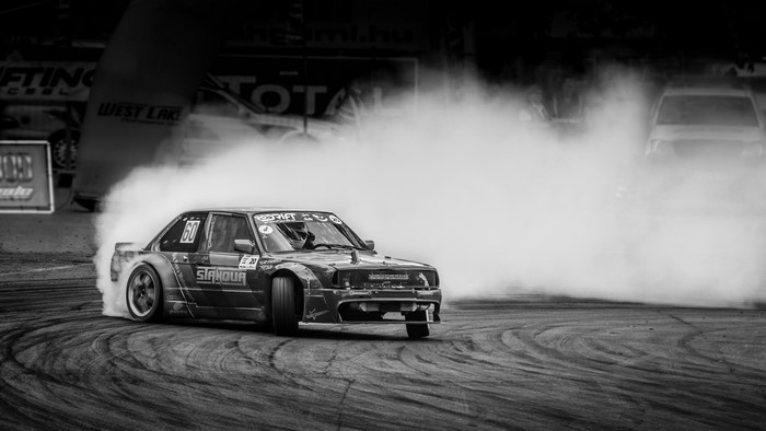 Drifting BMW car on race track with smoke