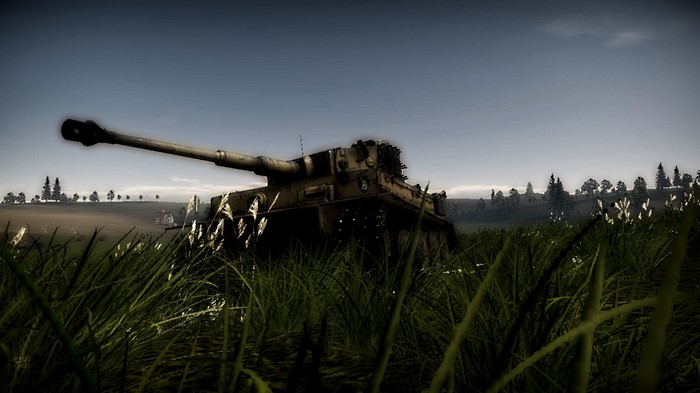 Tank in a grassy field with trees in the background