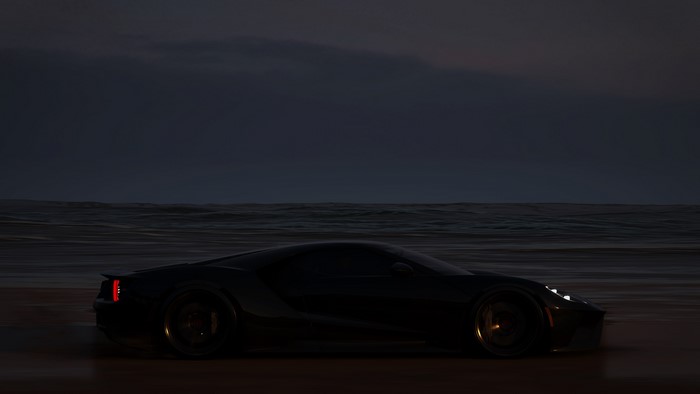 Dark Ford GT on a beach at dusk