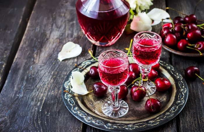 Cherry liqueur in glasses and decanter with cherries