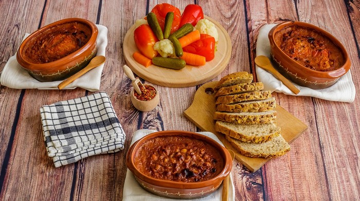 Baked beans with pickles, bread, and chili flakes