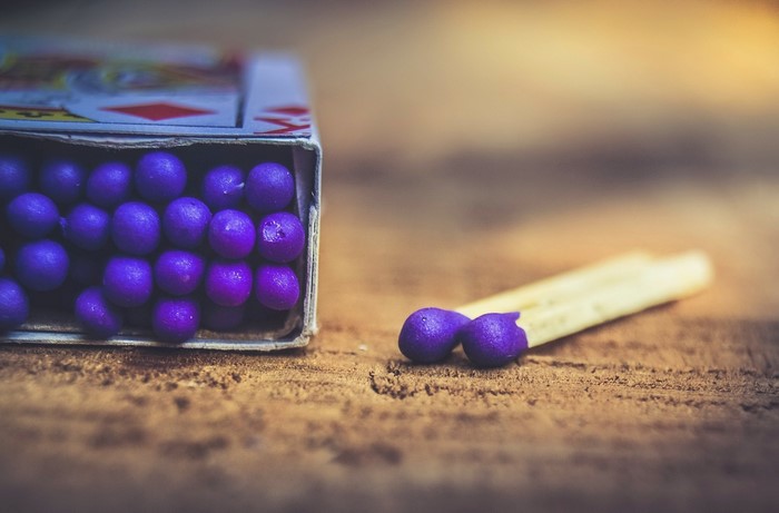 Purple matches in a box on a wooden surface