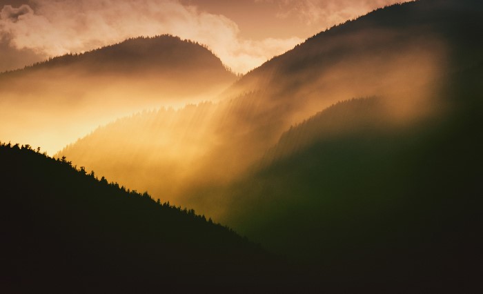 Misty mountains at sunrise with sunbeams