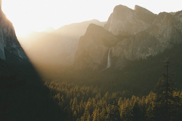 Sunlight over Yosemite Valley with Waterfall and Forest