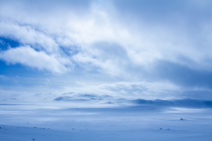 Snowy Arctic landscape with mountains and clouds