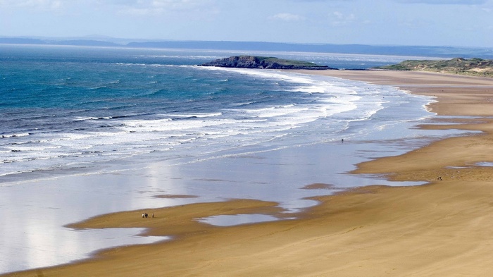 Sandy beach with waves and distant island
