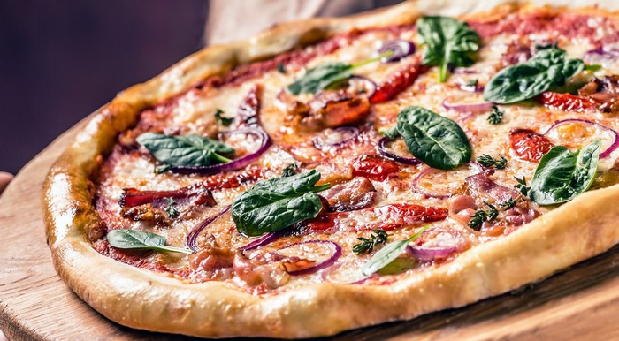 Pizza with cheese, onions, and spinach