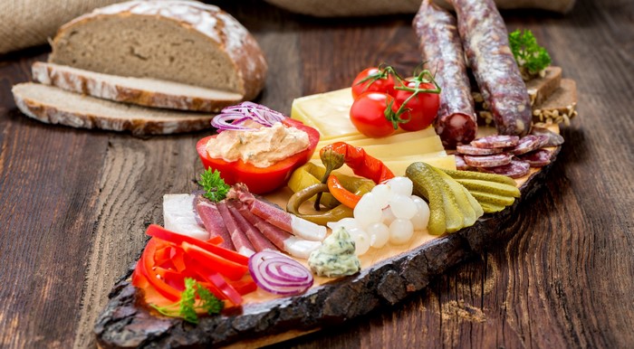 Charcuterie board with bread, cheese, and sausages