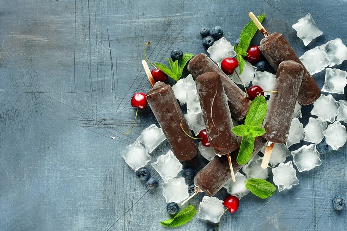 Chocolate popsicles with cherries, blueberries, mint, and ice