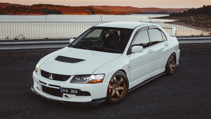 White Mitsubishi Lancer EVO parked by a lake
