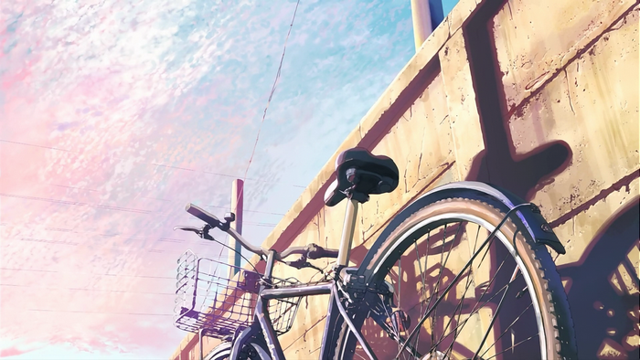 Bicycle leaning against a wall with a pink and blue sky