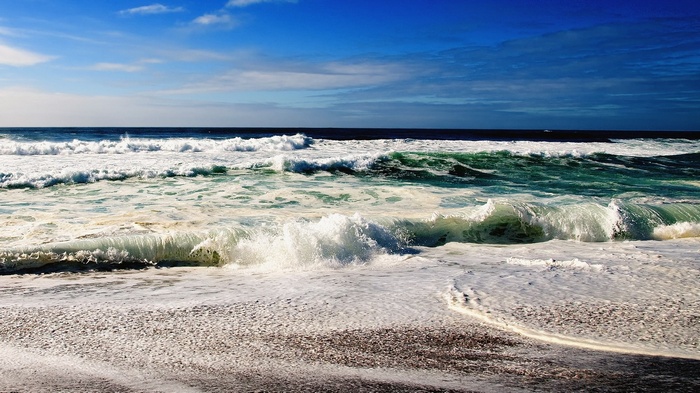 Ocean waves crashing on a sandy beach