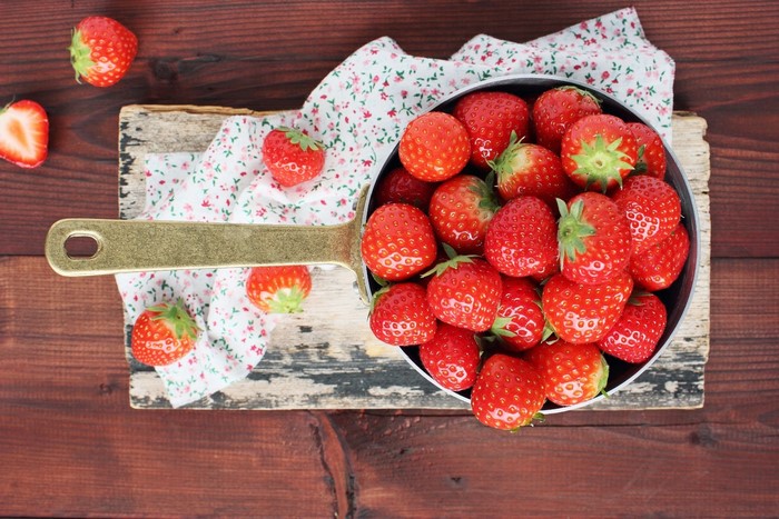 Strawberries in a pan on a cutting board