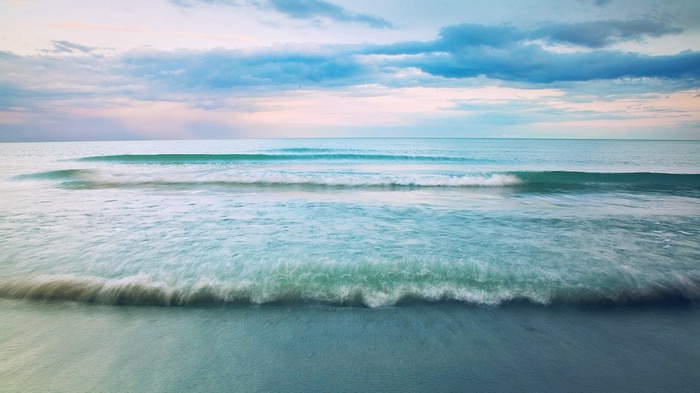 Ocean waves and clouds at sunset