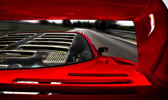Red Ferrari F40 driving on a road