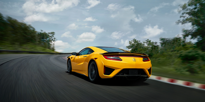 Yellow Acura NSX driving on a race track