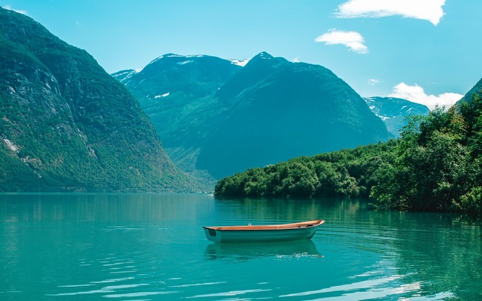 Boat on a lake with mountains and trees