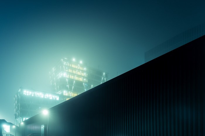 Modern buildings in fog at night