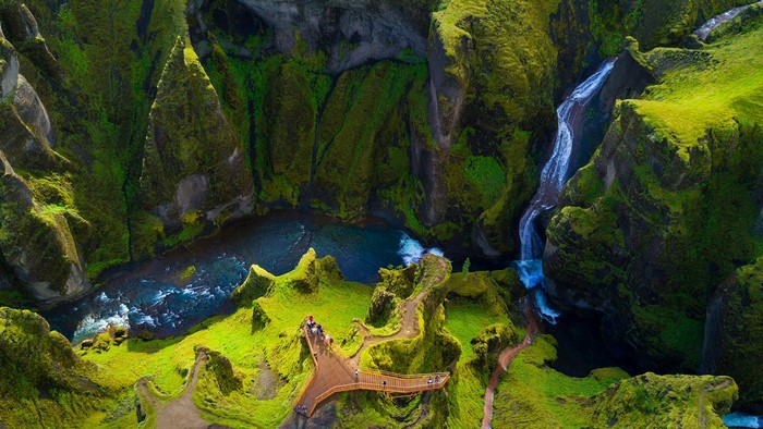 Fjaðrárgljúfur Canyon with Waterfall and Tourists in Iceland