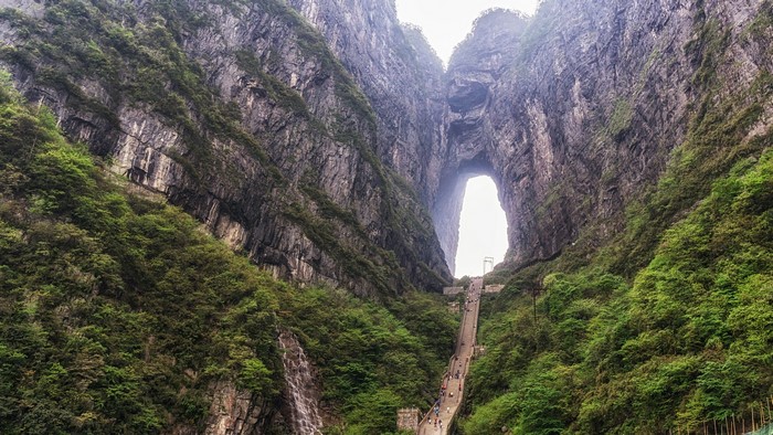 Tianmen Mountain natural arch with stairs and people
