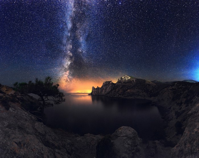 Milky Way over a rocky bay at night