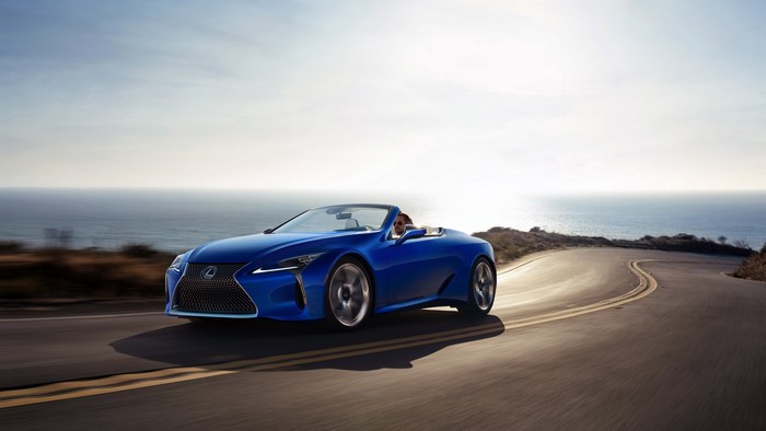 Blue Lexus LC-500 Convertible driving on coastal road at sunset