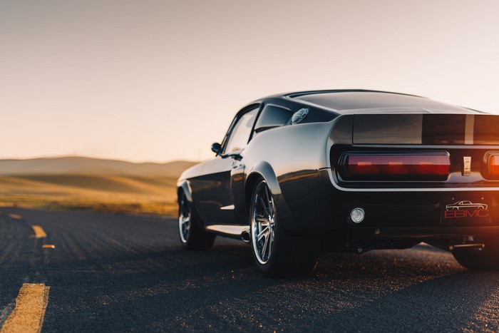 Black Ford Mustang Eleanor on a road at sunset