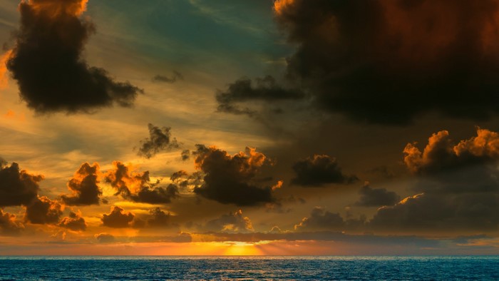 Sunset over the ocean with dramatic clouds