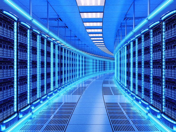 Blue glowing server room hallway with rows of servers