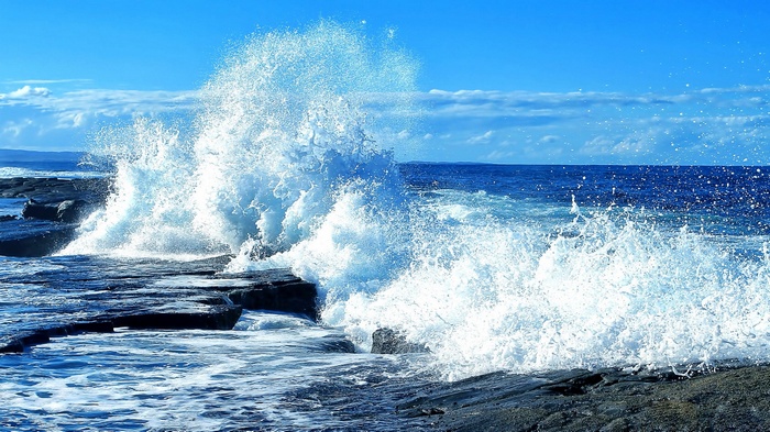 Ocean wave crashing on rocky shore