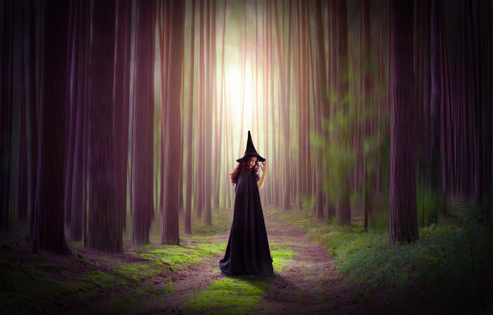 Witch in a dark forest with light filtering through trees