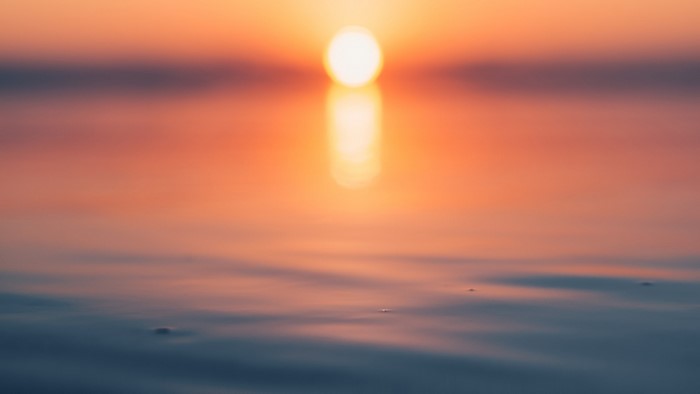 Sunset over calm water with reflection