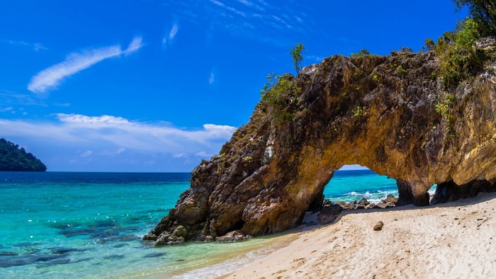 Arch rock formation on a tropical beach with turquoise water
