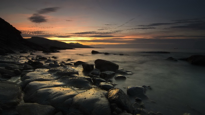 Rocky coastline at sunset with calm sea