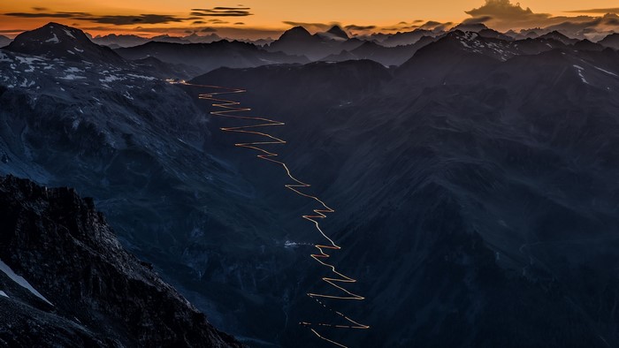 Stelvio Pass road with lights at sunset, Italy