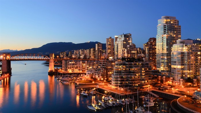 Vancouver cityscape with bridge and mountains at dusk